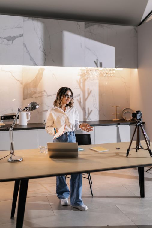 A creator recording a tutorial with a camera and laptop.