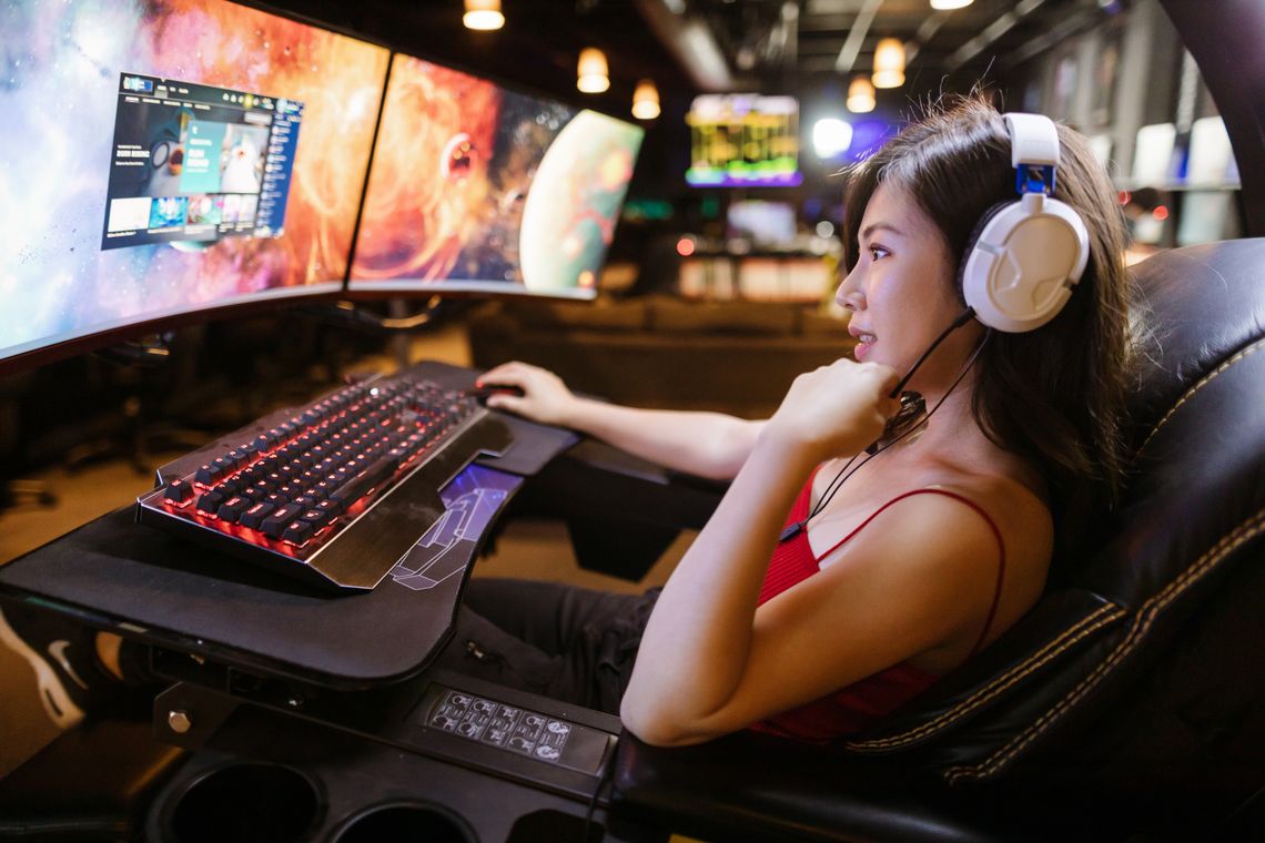 A gaming creator at a multi-monitor streaming setup.